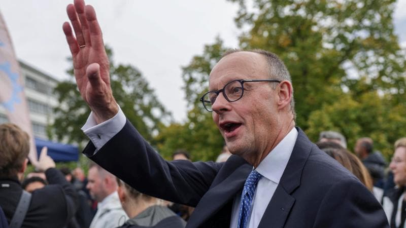 epa12428242 German Chancellor Friedrich Merz waves during a tour after celebrations for the Day of German Unity 2025 in Saarbruecken, Germany, 03 October 2025. German Unity Day is celebrated annually on 03 October to commemorate the reunification of East and West Germany in 1990.  EPA/CHRISTOPHER NEUNDORF