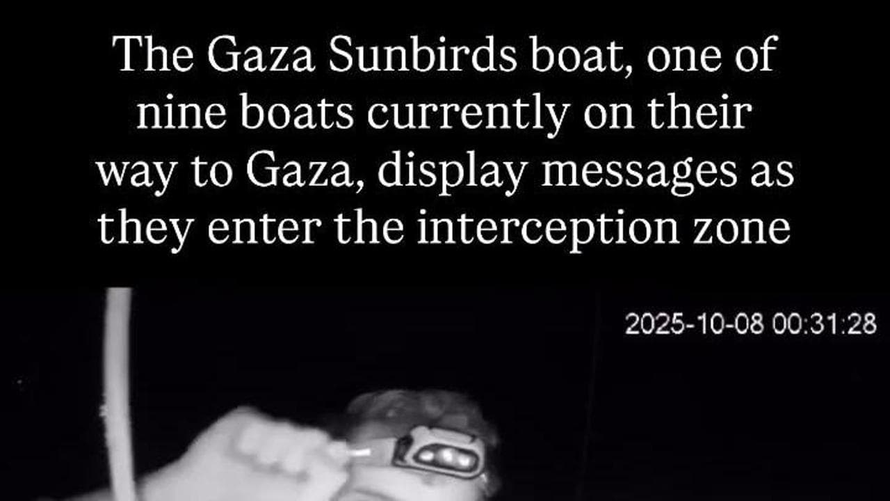 Flotilla, i cartelli per Gaza mostrati da un attivista prima dell'arrivo della marina israeliana