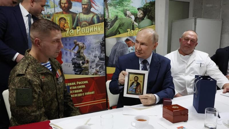 Vladimir Putin incontra i reduci feriti in Ucraina nell’ospedale militare centrale di Mosca. Alle sue spalle lo slogan “Per la patria"
