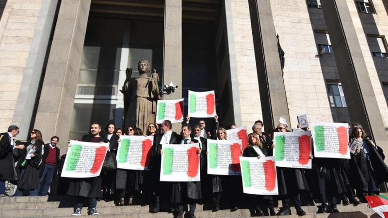Magistrati sulla scalinata d'ingresso del Palazzo di Giustizia in toga, con una coccarda tricolore e manifesti con frasi a difesa della Costituzione, in segno di protesta, nel giorno della cerimonia dell'inaugurazione dell'Anno giudiziario nel Distretto, contro il disegno di legge sulla separazione delle carriere, Catania, 25 gennaio 2025..ANSA/ ORIETTA SCARDINO