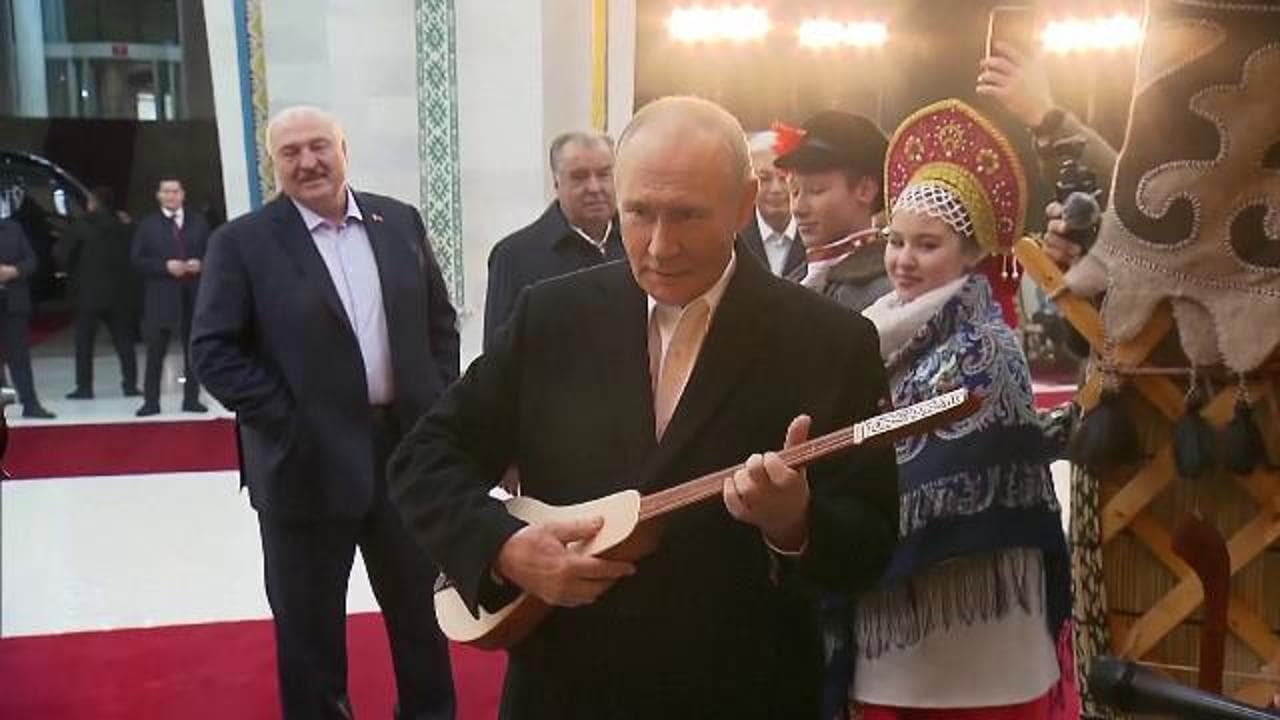 Putin cerca di suonare una chitarra del Kirghizistan durante la sua visita nel paese asiatico