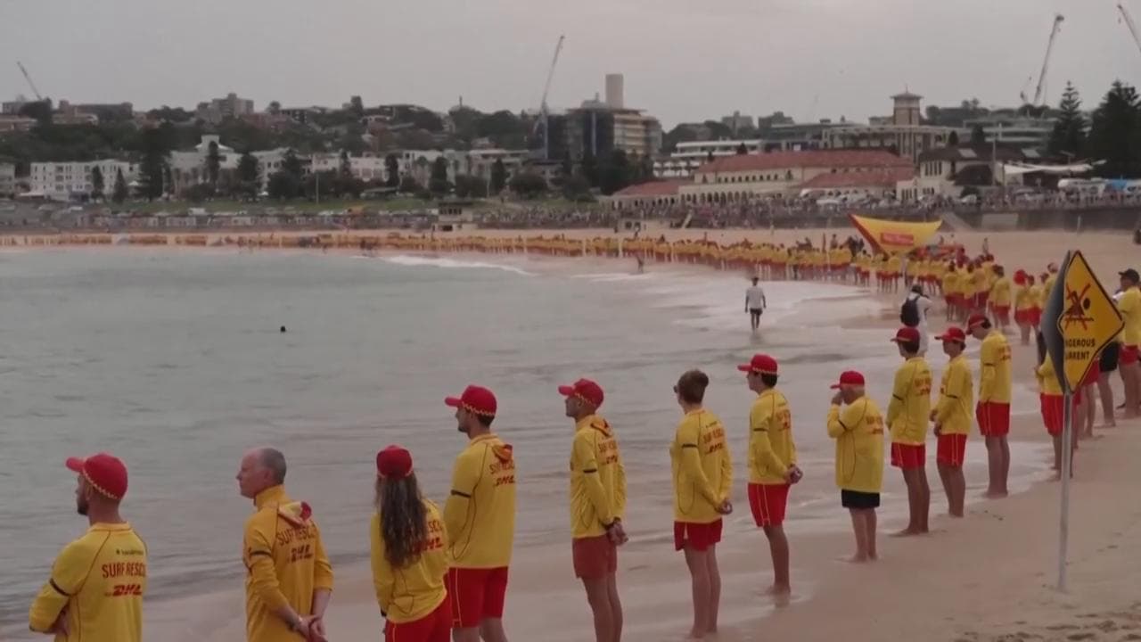 Bondi Beach, l'omaggio silenzioso di centinaia di bagnini sulla spiaggia alle vittime della strage