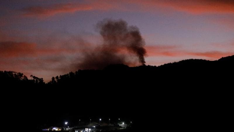 Smoke rises near Fort Tiuna during a full blackout, following explosions and loud noises, after U.S. President Donald Trump said the U.S. has struck Venezuela and captured its President Nicolas Maduro, in Caracas, Venezuela, January 3, 2026.  REUTERS/Leonardo Fernandez Viloria
