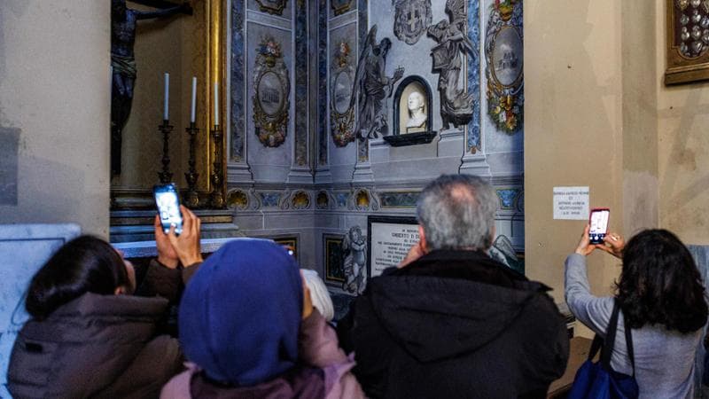 Fila di curiosi nella basilica di San Lorenzo in Lucina per l'affresco con il volto di Meloni
