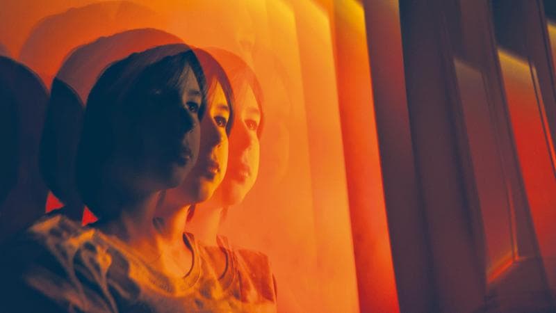 Multiple exposure of teenage boy in red light