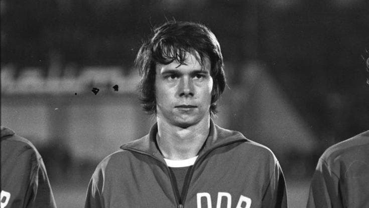 Jürgen Sparwasser, ottobre 1973, schierato per gli inni nazionali prima di una partita della sua nazionale. Fotografo: Rainer Mittelstädt. Fonte.
