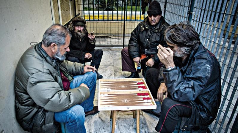 Un gruppo&nbsp;di uomini ritratti gioca a tavli,&nbsp;versione greca&nbsp; del backgammon, al porto del Pireo, Atene
