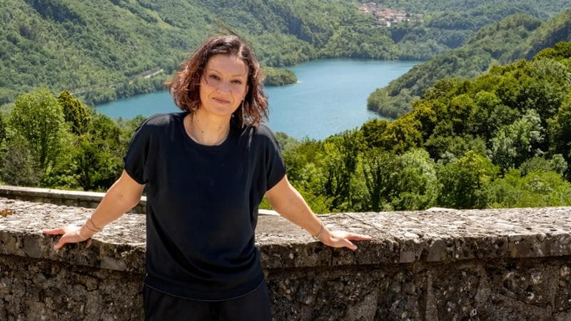 Ilaria Tuti sulla sulla Rupe di Cesclans, alle sue spalle il lago di Cavazzo. (Luigi Cozzarin)
