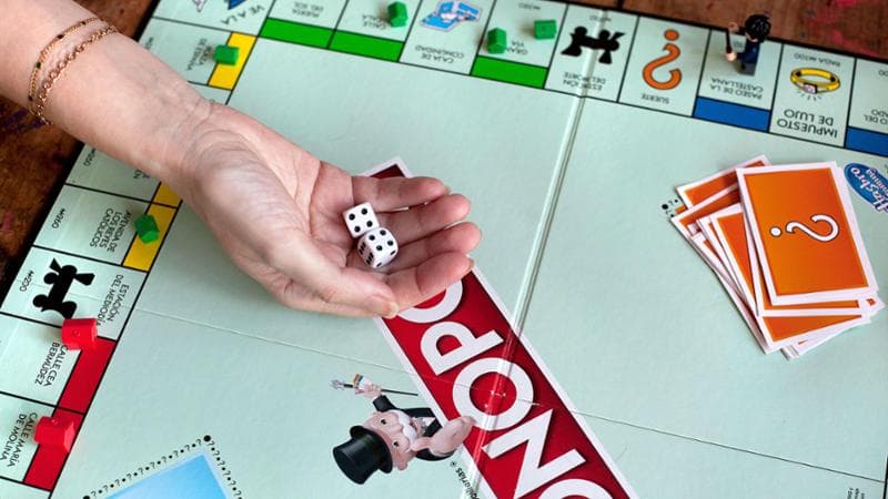 2K0PNT6 Rolling di during Monopoly game.