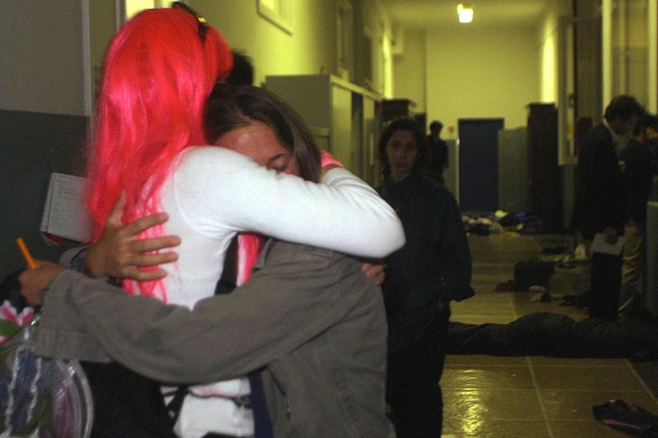 L’abbraccio tra due ragazze dopo il massacro alla scuola Diaz nella notte del 21 luglio 2001