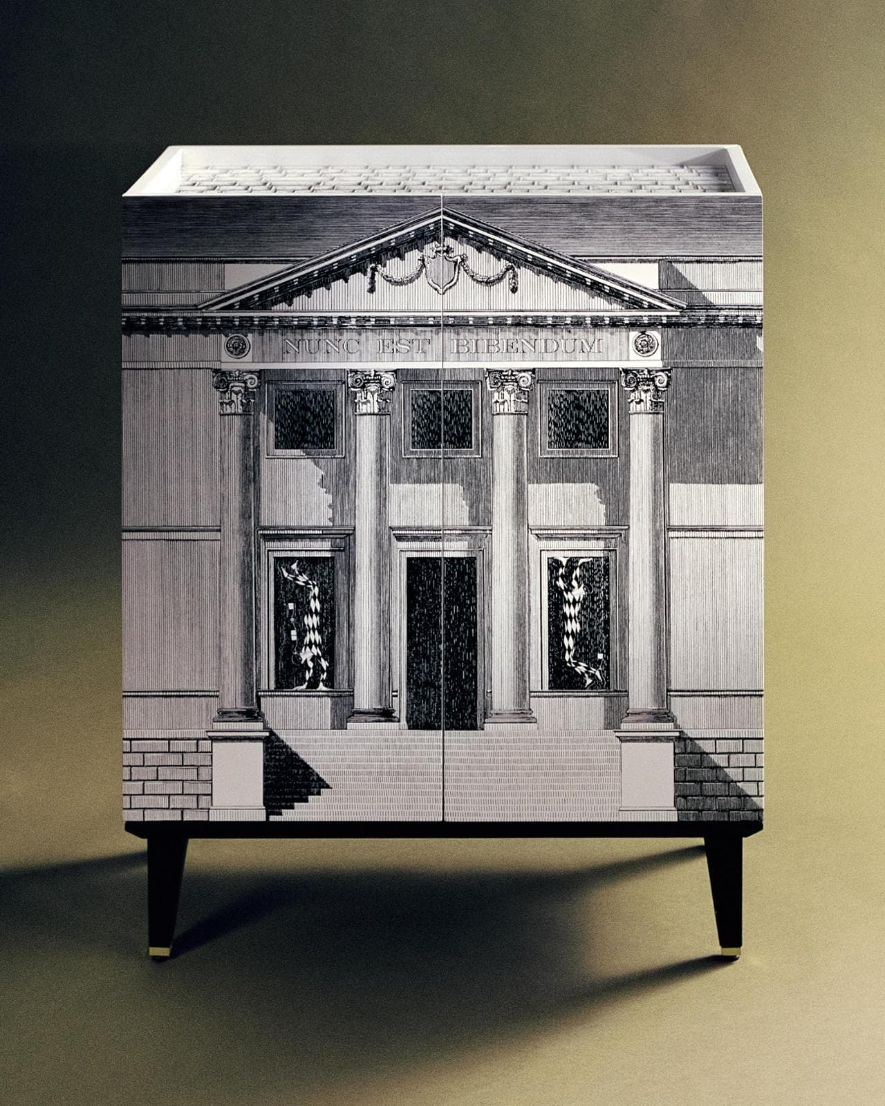 Scenografico e funzionale, Palladiana e Arlecchini è il nuovo cabinet-bar di Fornasetti: chiuso appare come un oggetto d’arte, aperto (nella foto di apertura) svela tutta la sua teatralità