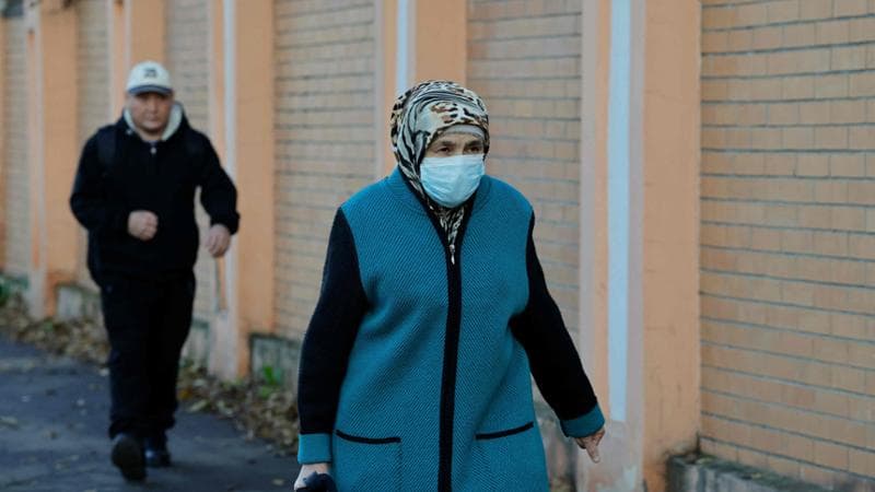 Una donna con una mascherina passa davanti all'Istituto di ricerca contro la peste di Irkutsk. Foto Tatyana Makeyeva/Afp