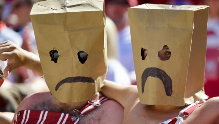 Due tifosi degli Arkansas Razorbacks con le buste di carta in testa