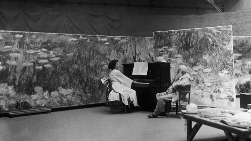 Un anziano Claude Monet (1840-1926) nel suo atelier di Giverny con la soprano americana Marguerite Namara, a cui dava lezioni di pittura (Getty images)