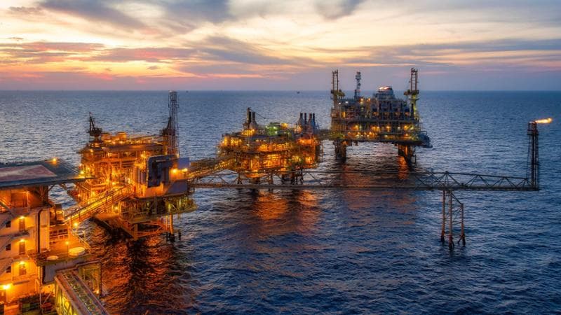 Offshore oil and gas platforms at sunset.