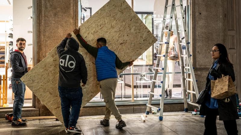 Milano, 23 ottobre: un negozio protegge le vetrine con pannelli di compensato