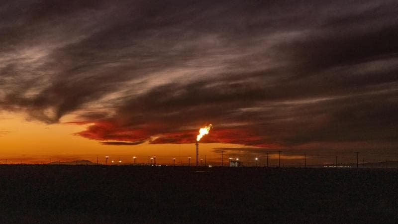 A gas flare near the Vaca Muerta shale formation in Añelo, Argentina, on 17 June 2026. Thousands of Argentines are flocking to a remote stretch of Patagonia, seeking work with only backpacks, tents and the hope that they and their country can turn around their fortunes. (Sarah Pabst/The New York Times)